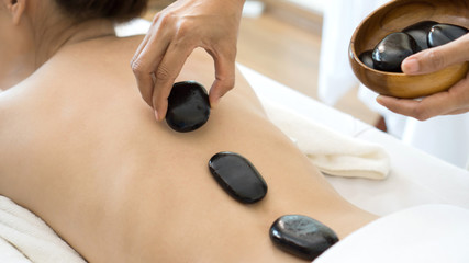 close up beautiful and healthy woman  during a back stone therapy massage in spa salon