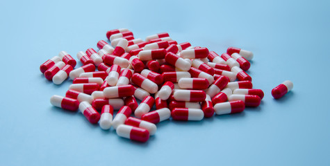 Pile of red capsules of pills on a pink background top view. Medicine Health Pharmacy Pharmacology Concept