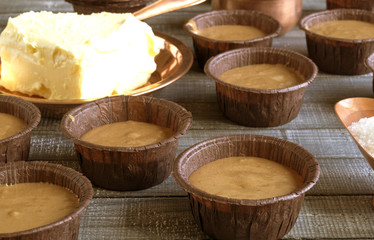 Ingredients for homemade chocolate cupcakes on wooden table.