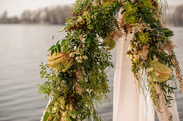 Beautiful wedding arch decorated with tropical flowers and white fabric