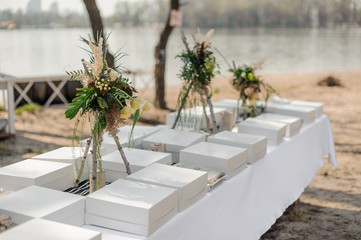 Festive wedding table served with food boxes and decorated with fresh tropical flowers