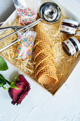 waffle ice cream cups in a gift box with a spoon for ice cream, topping and confectionery sprinkles