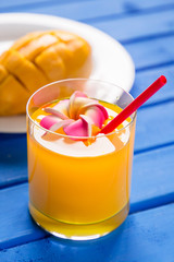 Mango smoothie in a glass glass and mango on a blue background. Mango shake.