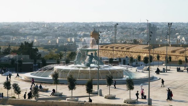 Tourists walking along Triton Square in Valletta, Malta.
