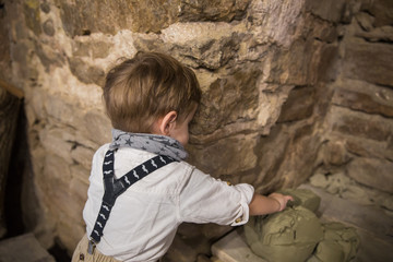 Obraz na płótnie Canvas The little boy climbing out of clay indoors