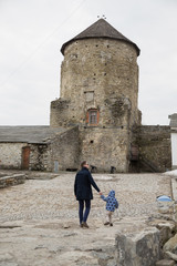 The happy young father walking with his little son near the castle