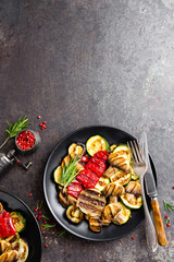 Grilled vegetable salad. Salad of barbecued zucchini, eggplant, sweet pepper, onion and mushrooms on black plate