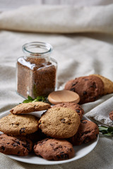 Roasted coffee beans get out of overturned glass jar on homespun tablecloth, selective focus, side view