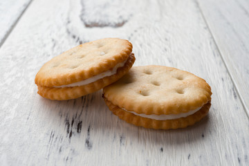 sandwich biscuits with white cream filling on white wood background