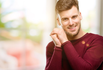 Handsome young man confident and happy with a big natural smile laughing