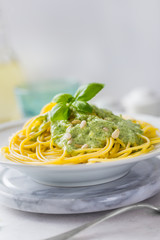Dish with spaghetti topped with green sauce