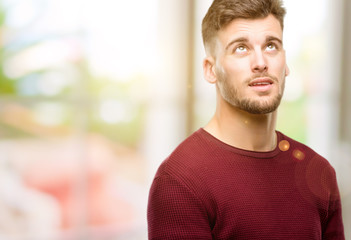 Obraz premium Handsome young man confident and happy with a big natural smile laughing looking up