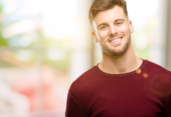 Handsome young man confident and happy with a big natural smile laughing, natural expression