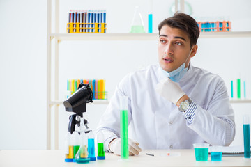 Young chemist student working in lab on chemicals