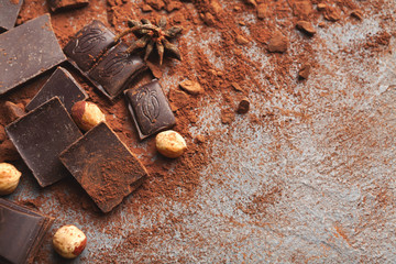 Crushed chocolate bar pieces and cocoa on gray background