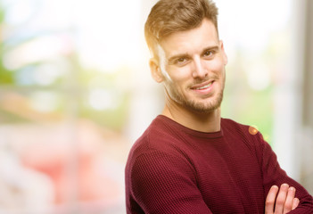 Obraz premium Handsome young man with crossed arms confident and happy with a big natural smile laughing