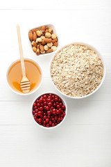 Oat flakes with currant, honey and nuts on wooden table