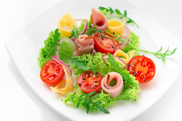 Fresh salad with tomatoes, arugula, cheese and ham on the white plate and white background