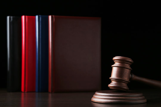 Judge gavel with books on wooden table