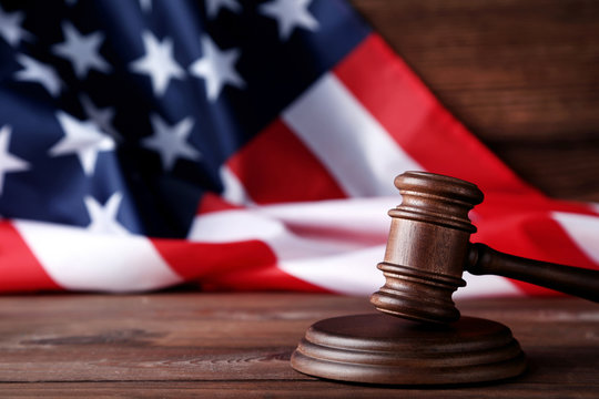 Judge gavel with american flag on wooden table