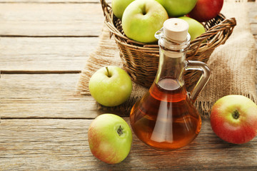 Apple vinegar in glass bottle on grey wooden table