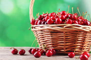 Sweet cherries in basket on wooden table