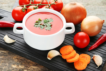 Tomato soup with parsley on grey wooden table