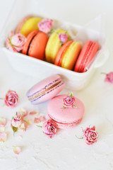 Dessert: A Delicate Fresh Colorful French Macaroons In Pastel Colors Gift Box Flowers Roses On Light Textiles Background