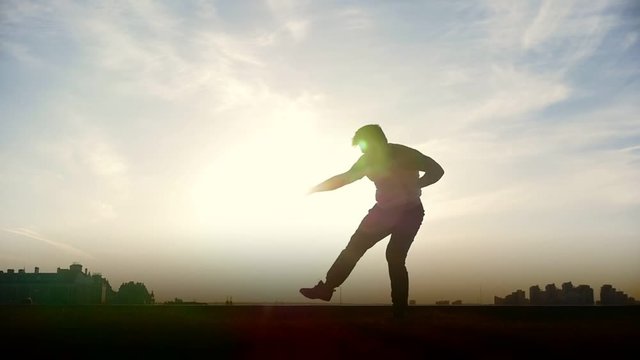 Slow-motion - young male Parkour tricker jumper performs amazing flips in front of the sun