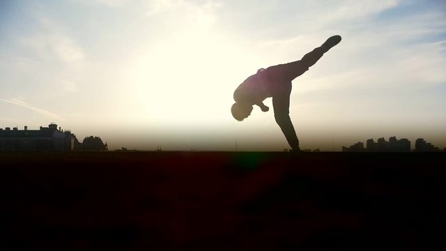 Man Parkour tricker jumper performs amazing flips, silhouette