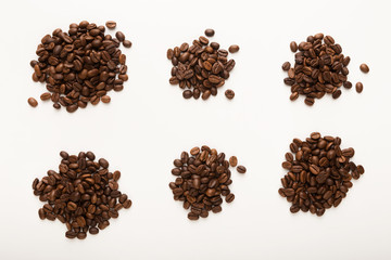 Heaps of brown coffee beans isolated on white