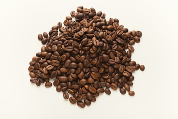 Heap of brown coffee beans isolated on white