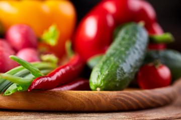 Composition of vegetables on flat plate on wooden table, close-up, selective focus