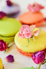 Delicate Fresh Colorful French Macaroons In Pastel Colors With Flowers Roses On A Light Textile Background