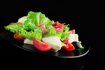 Fresh tasty salad on a glossy black background