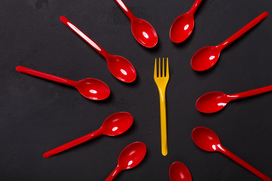 Top view on plastic fork and spoons on black background