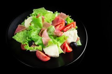 Fresh tasty salad on a glossy black background