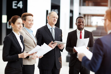 Group of successful financial experts listening to colleague report about analysis of financial rates and situation on market