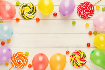 Colorful balloons on white rustic wood, birthday background, top