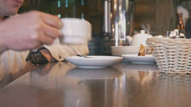 Man in caffee drinks coffee or tea