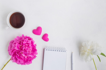 Flat lay desk with pink peony, gold notebook and accessories