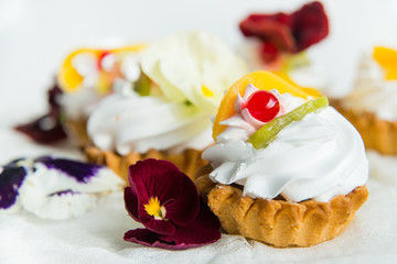 cake with fresh fruit and edible flowers Pansy Flowers on light background