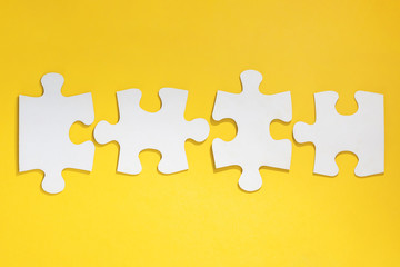 disconnected jigsaw puzzle in row on yellow background. Blank with four pieces