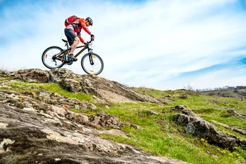 Gordijnen Cyclist in Red Jacket Riding Mountain Bike Down Rocky Hill. Extreme Sport and Adventure Concept. © Maksym Protsenko