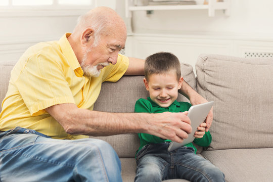 Grandfather taking touch pad from child