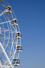 Ferris wheel over blue sky. Carousel. Cubicle. Joy.