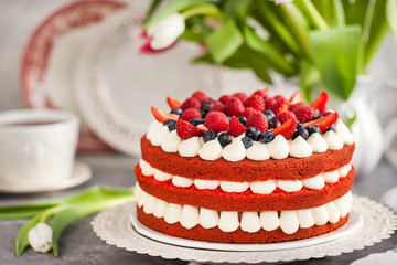 Delicious homemade red velvet cake decorated with cream and fresh berries