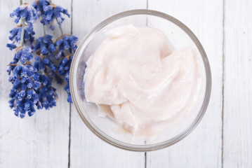 cosmetic cream and lavender flowers on white wood table background