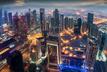 Luftaufnahme der beleuchteten Hochhäuser im Zentrum von Doha, Katar, am Abend
