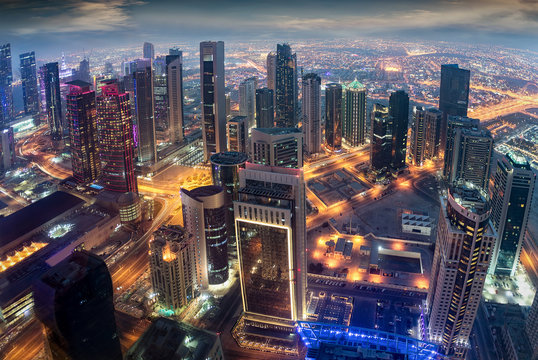 Luftaufnahme der beleuchteten Hochh&auml;user im Zentrum von Doha, Katar, am Abend